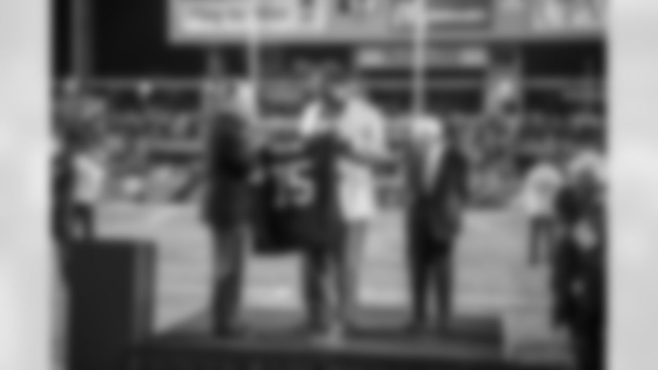 Steelers President Art Rooney II and Chairman Dan Rooney present former Steeler Joe Greene with his jersey as his number is retired.