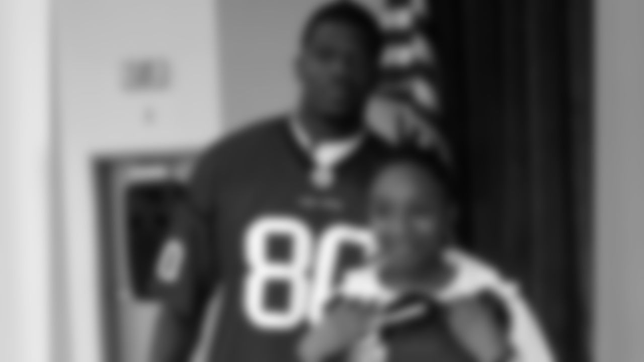 Johnson congratulates a young girl who just won an autographed DeMeco Ryans jersey.