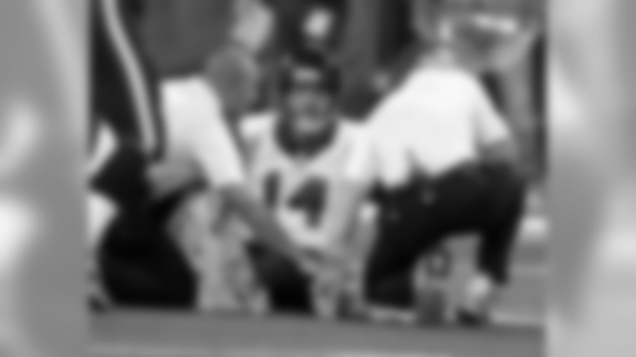 Houston Texans quarterback Ryan Fitzpatrick (14) is treated on the field after being injured during the first half of an NFL football game against the Indianapolis Colts in Indianapolis, Sunday, Dec. 14, 2014. (AP Photo/Darron Cummings)