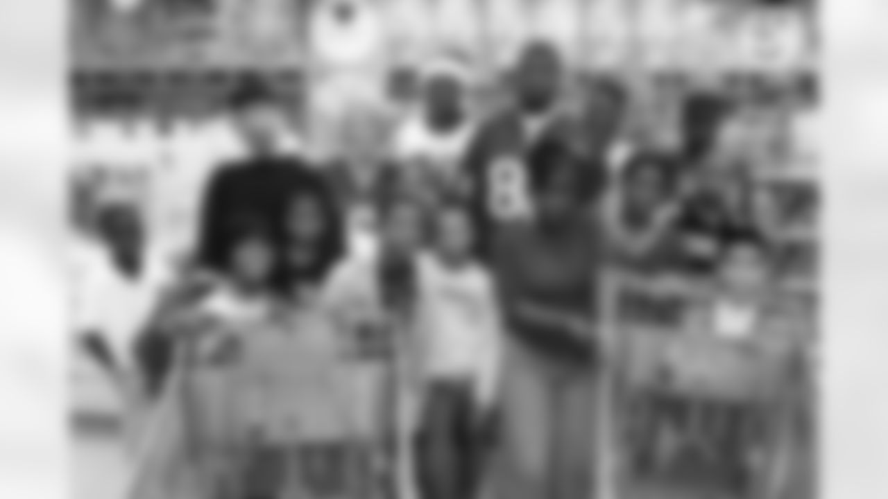 Johnson, with his own mother in the white Andre Johnson jersey and the mothers of Texans quarterback Matt Schaub, to his right, and wide receiver Jacoby Jones, to his left, stop for a photo with the 12 children before the shopping spree begins.