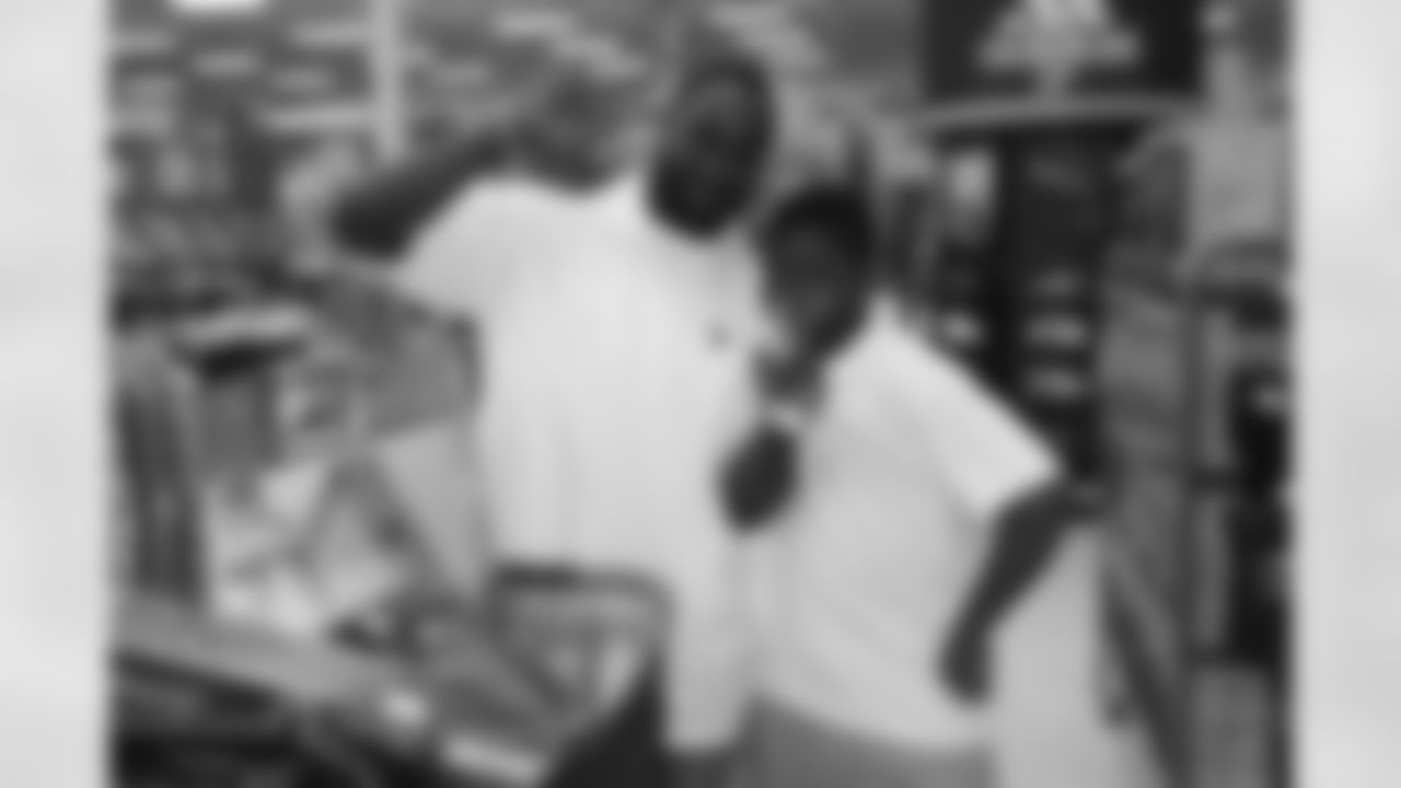 Rookie wide receiver Darnell Jenkins poses with a child during the $100 dollar shopping spree.