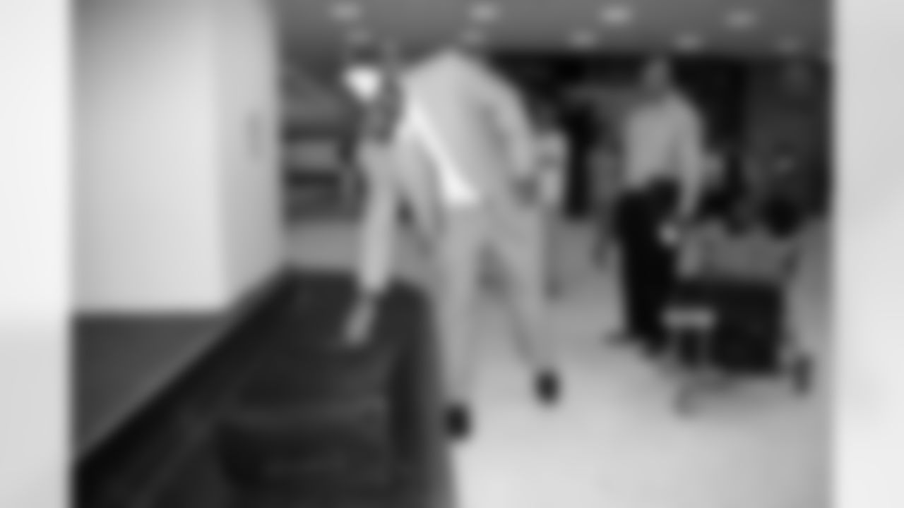 Brown picks up his suitcase from the baggage claim.
