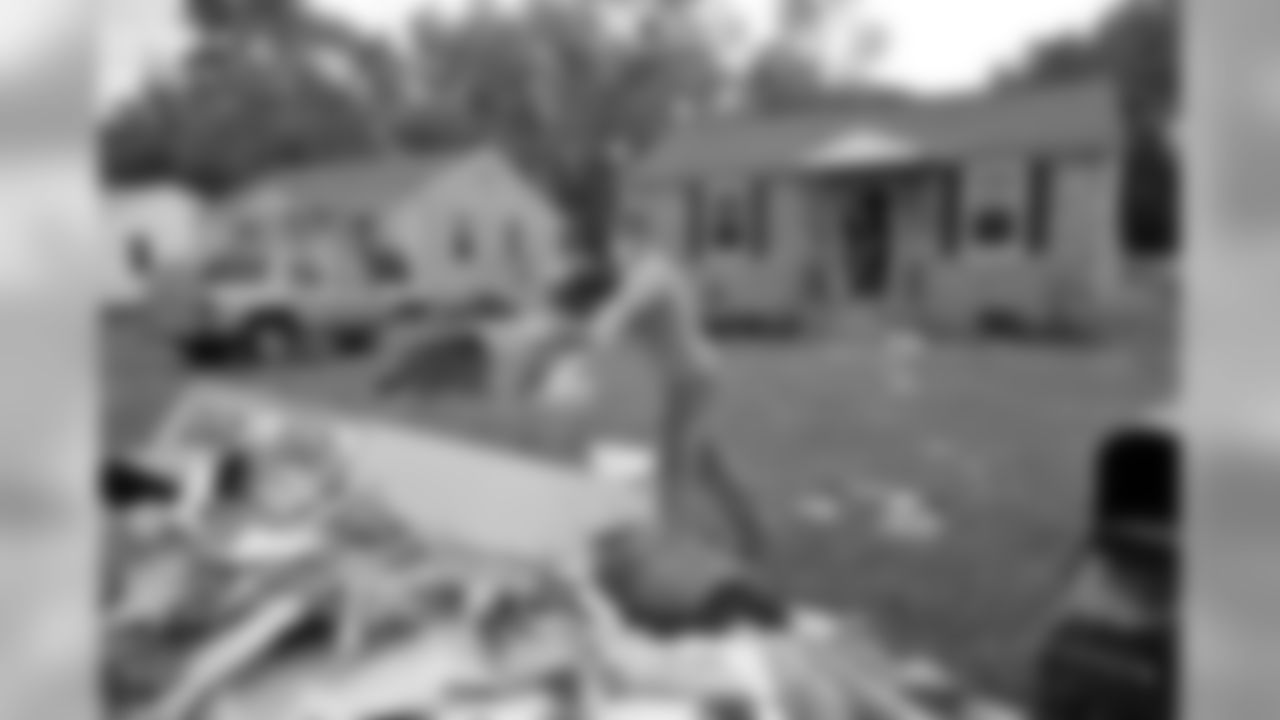 Tennessee Titans players, coaches and staff assist in cleanup efforts and removal of debris from wrecked homes caused from the historical flooding in a west Nashville neighborhood on Wednesday, May 11, 2010.
