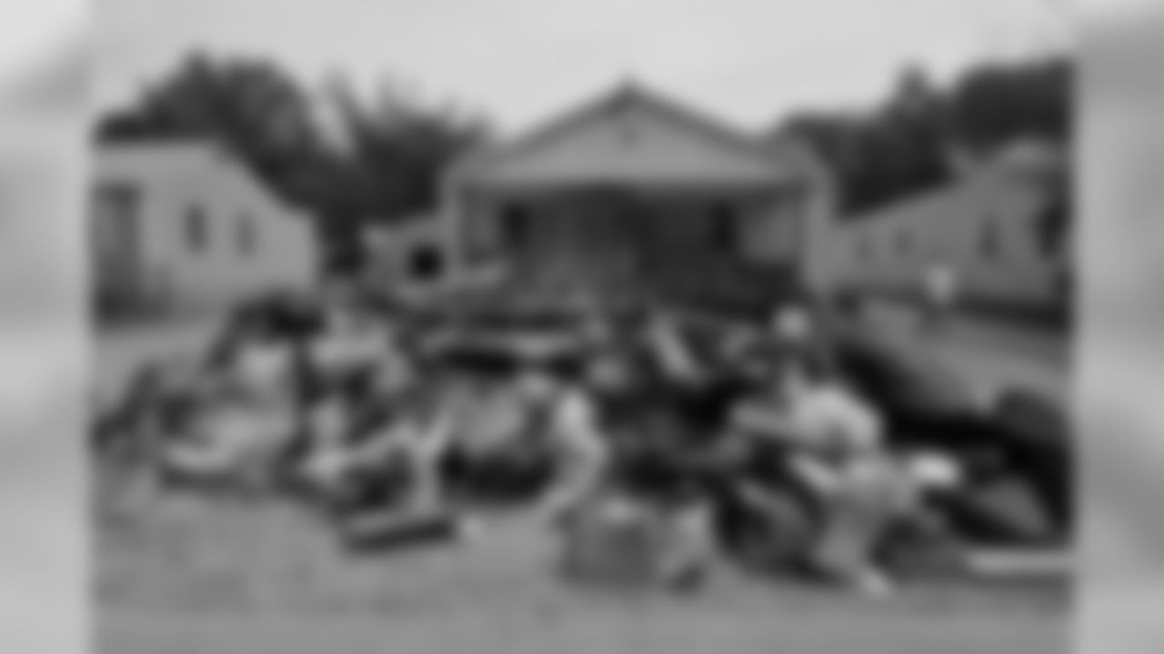 Tennessee Titans players, coaches and staff assist in cleanup efforts and removal of debris from wrecked homes caused from the historical flooding in a west Nashville neighborhood on Wednesday, May 11, 2010.