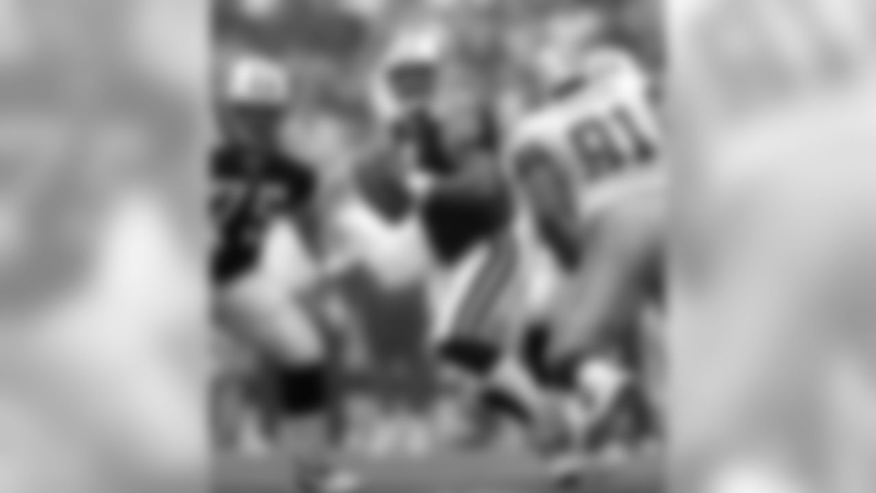 * FILE * Tennessee Titans quarterback Steve McNair (9) drops back to pass as teammate Benji Olson (75) looks to block Dallas Cowboys' Leonardo Carson (91) in Irving, Texas, Aug. 30, 2004. McNair said Friday, April 8, 2005 that he will return for his 11th season after an injured sternum plagued him for most of 2004. (AP Photo/Tony Gutierrez)