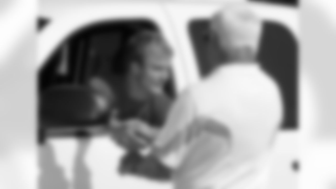 Wide receiver Marc Mariani is greeted by Steve Berk, right, director of security, as Mariani arrives at the team's NFL football facility on Tuesday, July 26, 2011, in Nashville, Tenn. Players started returning to the facility Tuesday morning, and they are
