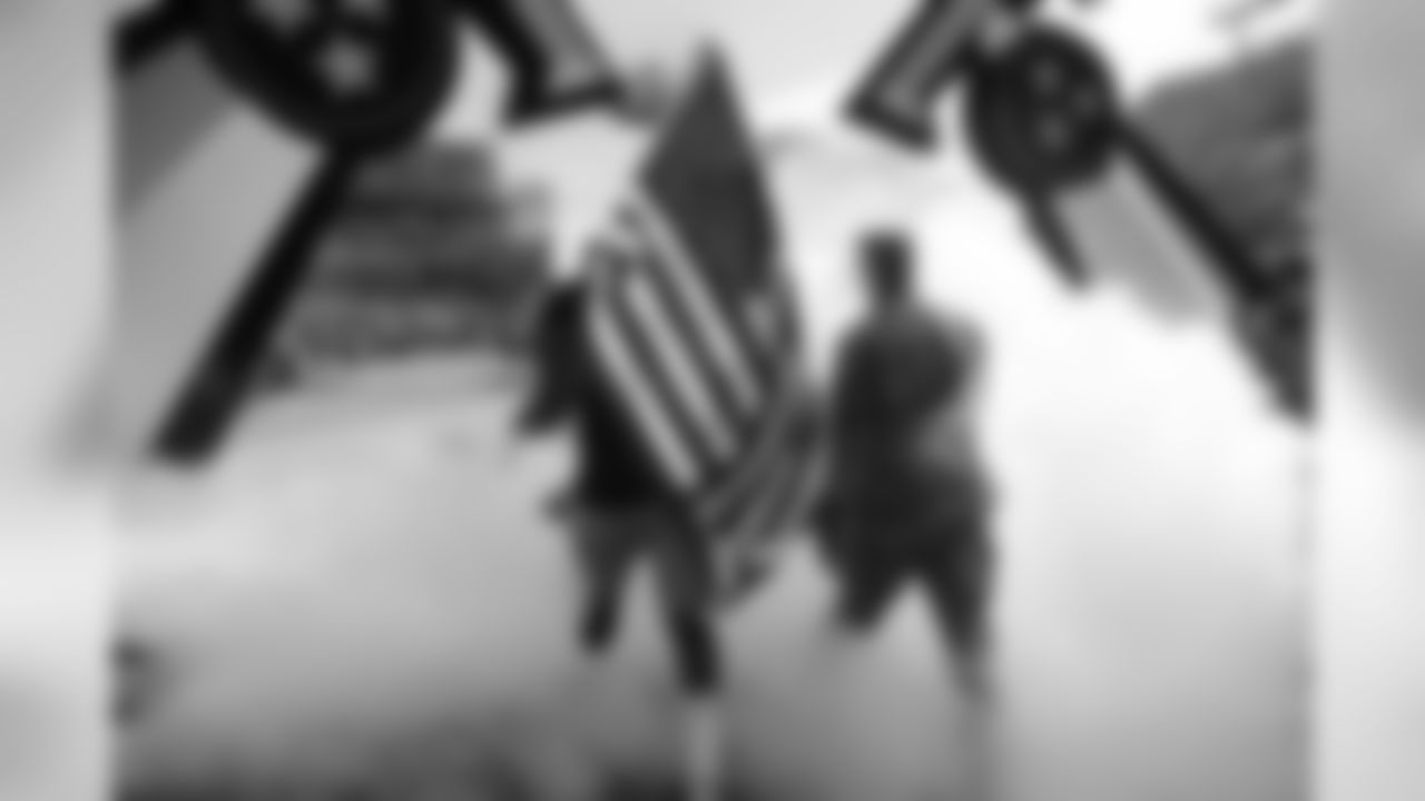 Tennessee Titans defensive end Jurrell Casey walks with a soldier and carries an American flag onto the field before an NFL football game between the Titans and the New England Patriots Sunday, Nov. 11, 2018, in Nashville, Tenn. (AP Photo/James Kenney)