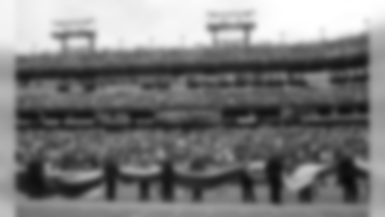 Emergency responders carry a flag onto the field before an NFL football game between the Tennessee Titans and the Houston Texans Sunday, Sept. 16, 2018, in Nashville, Tenn. (AP Photo/Mark Zaleski)