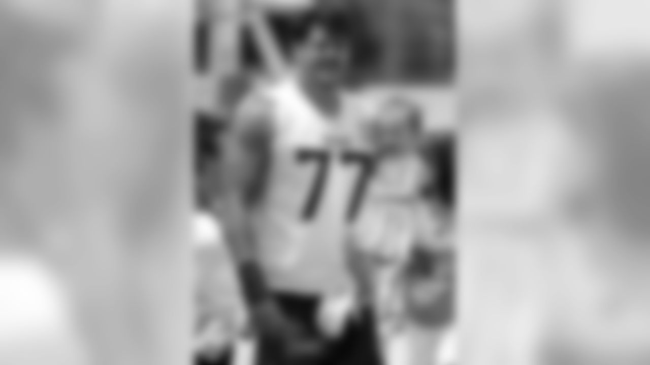 Tennessee Titans offensive tackle Taylor Lewan carries his daughter, Wynne, 1, as he leaves the field following the first day of practice at NFL football training camp Thursday, July 26, 2018, in Nashville, Tenn. (AP Photo/Mark Humphrey)