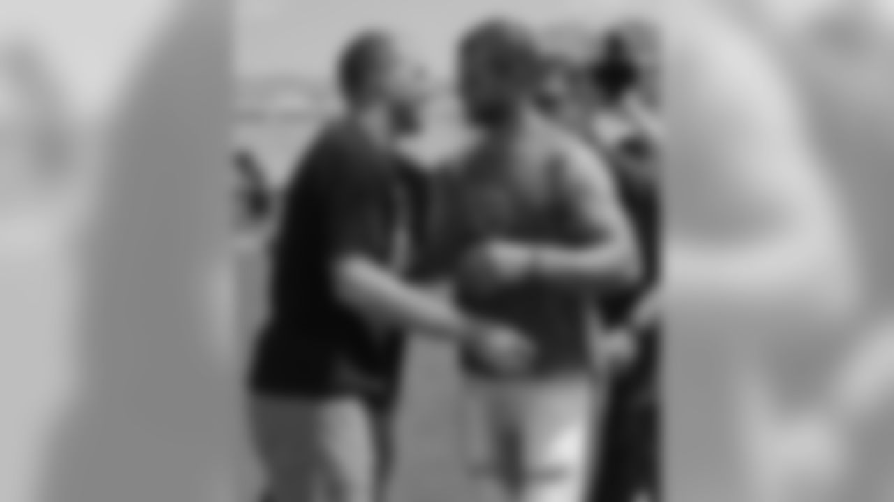 Former Tennessee Titans linebacker Tim Shaw, left, is greeted by quarterback Jake Locker after the Titans players, coaches and staff took part in the ALS Ice Bucket Challenge after NFL football practice on Wednesday, Aug. 20, 2014, in Nashville, Tenn. Shaw has announced that he has ALS, and visited the facility and witnessed the event that raises money and awareness to battle the disease. (AP Photo/Mark Humphrey)