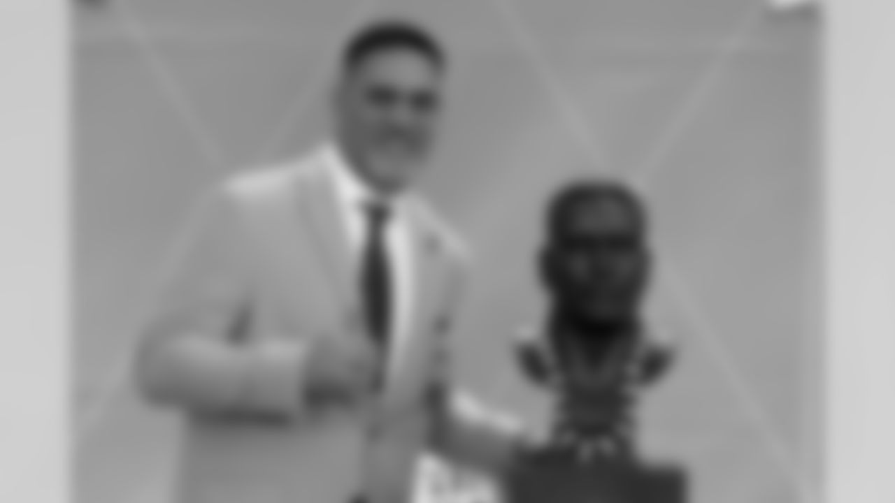 Former NFL player Kevin Mawae poses with a bust of himself during the induction ceremony at the Pro Football Hall of Fame, Saturday, Aug. 3, 2019, in Canton, Ohio. (AP Photo/Ron Schwane)