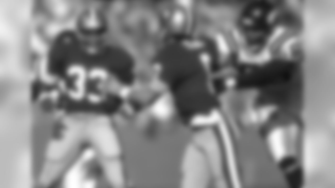San Francisco 49ers quarterback Steve Young (8) tires to escape the grasp of Minnesota Vikings defensive end Chris Doleman (56) and pass to San Francisco 49ers running back Roger Craig (33) during an NFL game against the on Sunday, Oct. 30, 1988, in San Francisco. The 49ers won the game, 24-21. (AP Photo/Greg Trott)