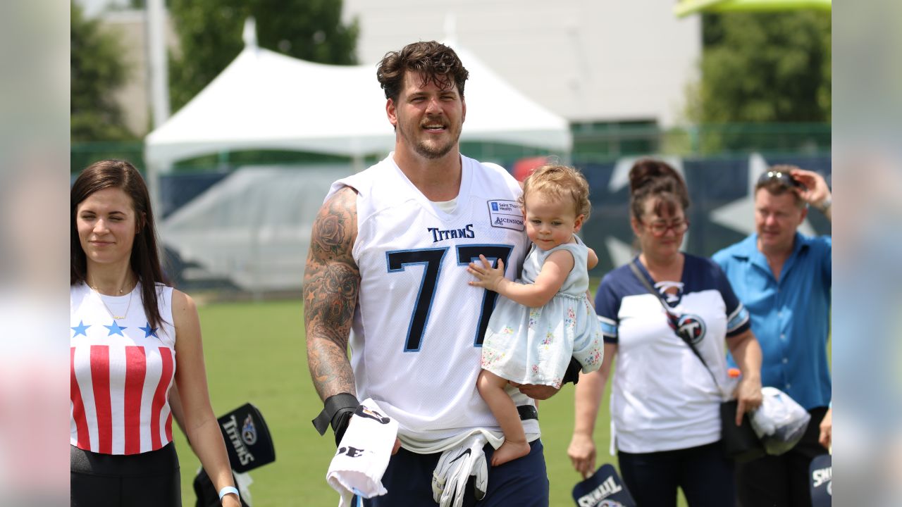 Tennessee Titans offensive tackle Taylor Lewan carries his daughter, Wynne,  1, as he leaves the field following the first day of practice at NFL  football training camp Thursday, July 26, 2018, in