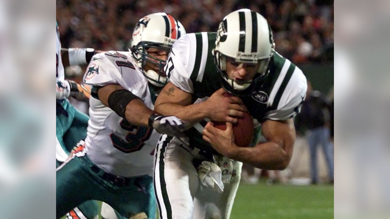 Miami Dolphins quarterback Dan Marino is sacked by New York Jets defensive  end Marvin Washington for a two yard loss in the second quarter of NFL play  in East Rutherford, New Jersey