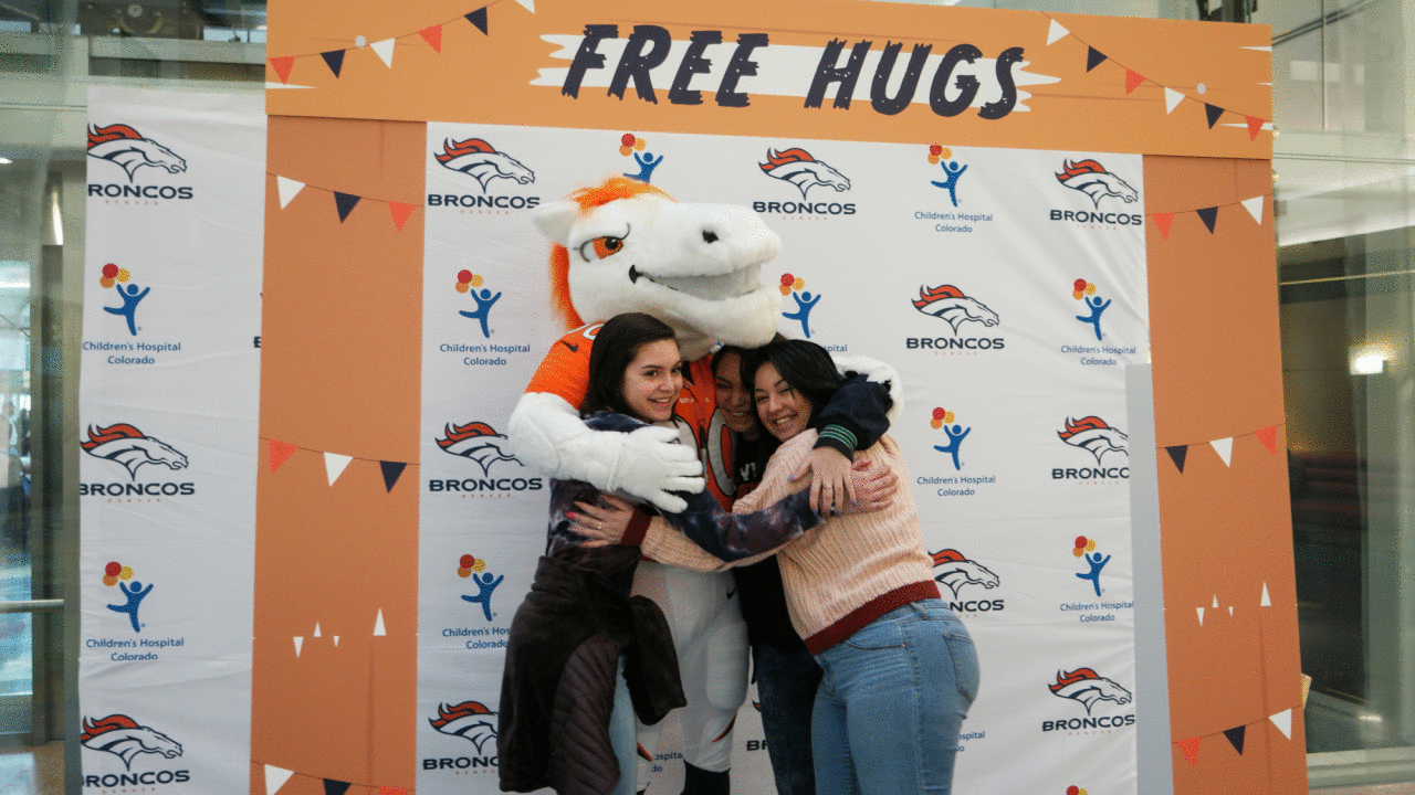 Miles the mascot gives out free hugs at a booth set up at Children's Hospital Colorado during a visit for Random Acts of Kindness Week on February 19, 2019.