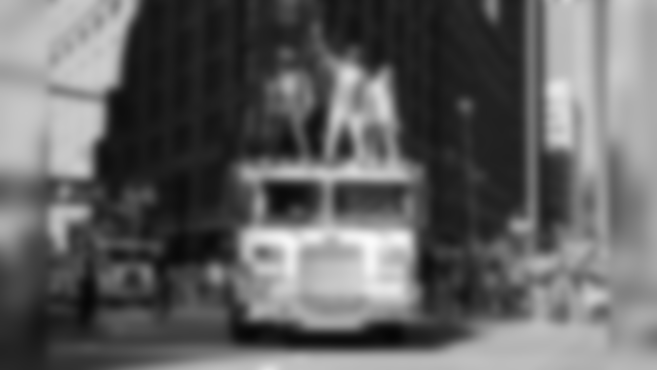 Demaryius Thomas stands atop a fire truck and waves to the crowd during the Broncos' championship parade through downtown Denver on Feb. 9, 2016.