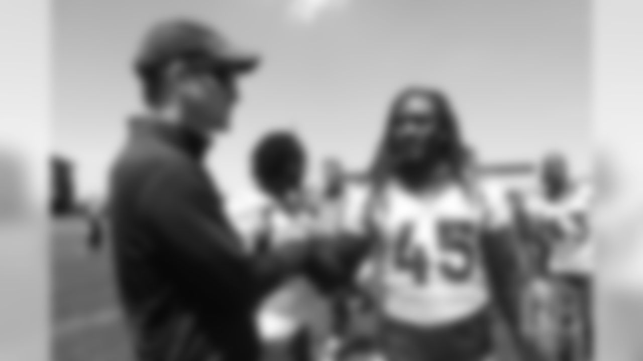 Alexander Johnson greets former Broncos quarterback Peyton Manning after the Broncos' practice on the eight day of their OTAs on May 30, 2019.