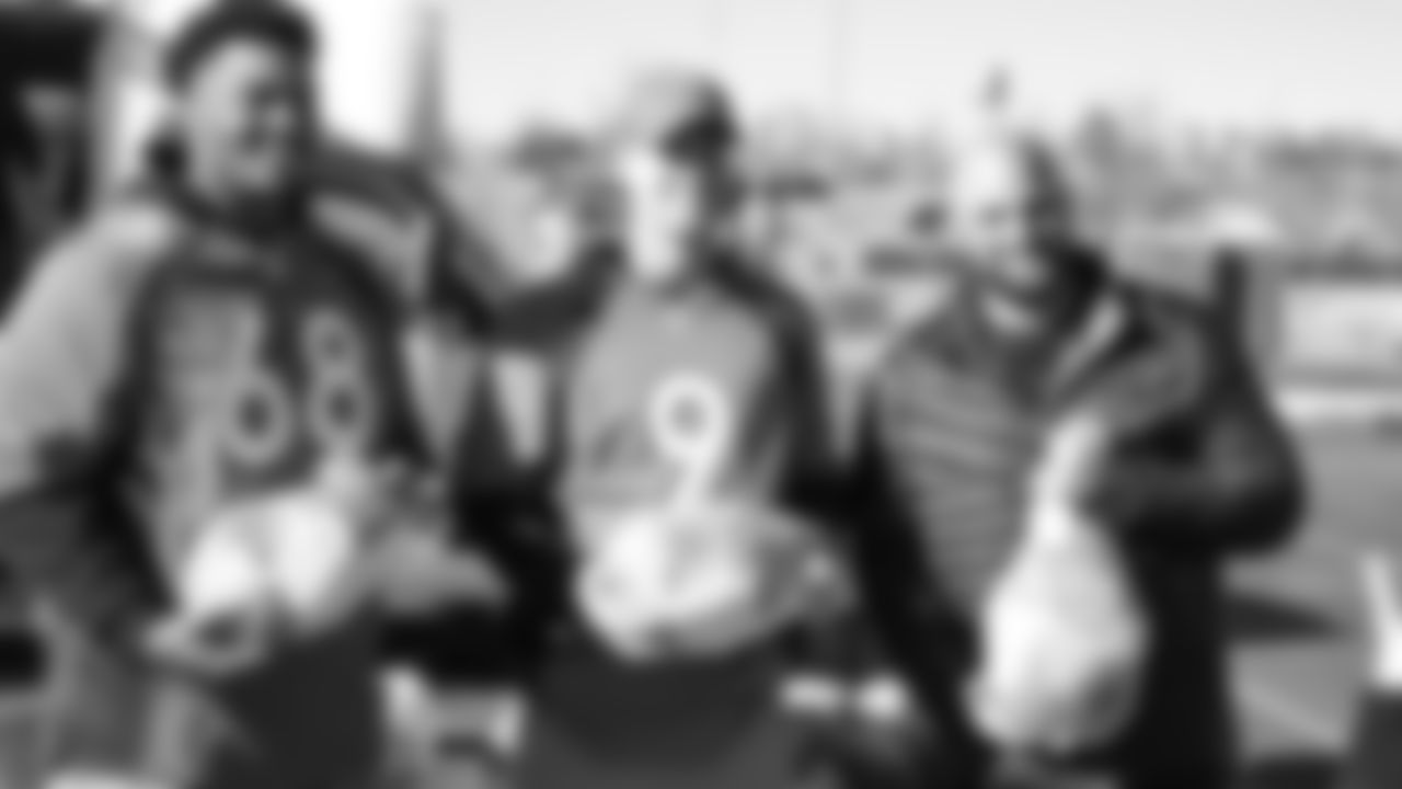 (From left) Elijah Wilkinson, Kevin Hogan and Gino Gradkowski during the Denver Rescue Mission's Thanksgiving Turkey in a Box distribution on Nov. 20, 2018