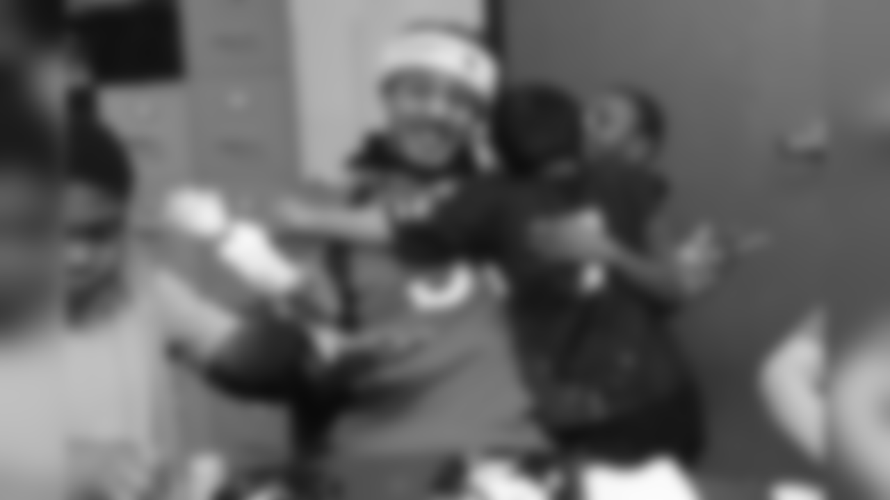 Shane Ray receives a hug from two boys at the Denver Rescue Mission's 19th annual holiday party.