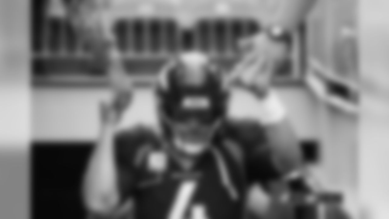 Case Keenum offers fist bumps with fans as he runs out of the tunnel during pregame warmups before the Broncos' Week 4 matchup with the Chiefs.