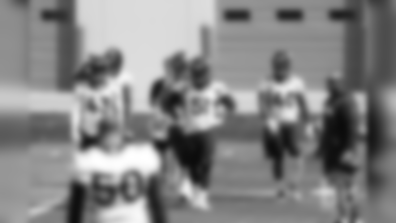 Linebackers Joe Jones, Todd Davis and Keishawn Bierria walk to the center of the field during the first day of voluntary veteran minicamp on April 16, 2019.