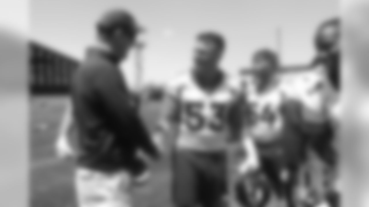 Joe Dineen greets former Broncos quarterback Peyton Manning after the Broncos' practice on the eight day of their OTAs on May 30, 2019.