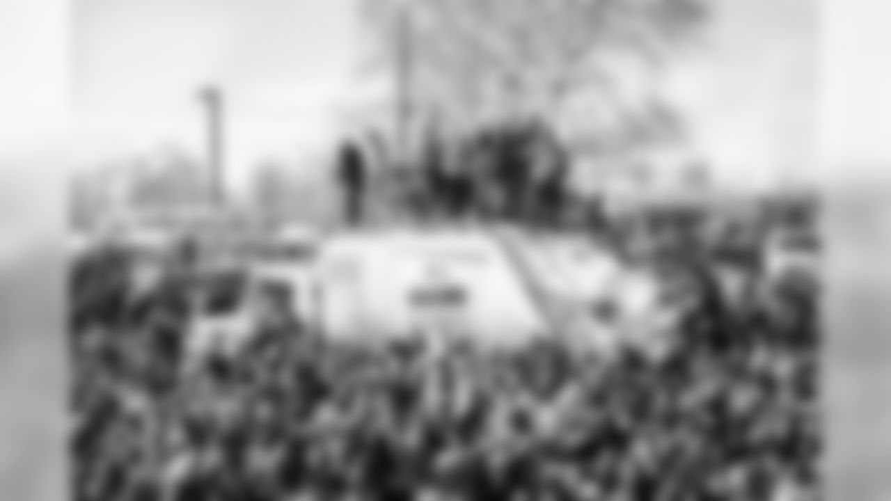These fans climbed on top of a garbage truck to get a better view.