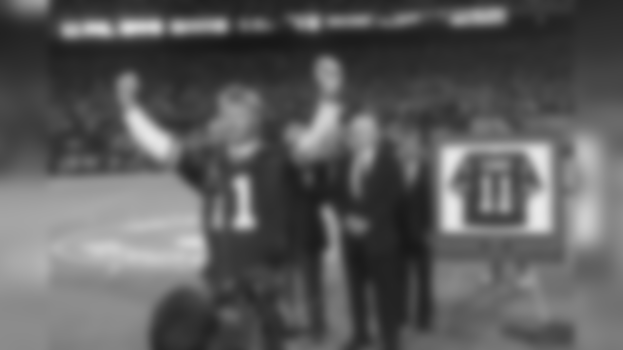 Former New York Giants quarterback Phil Simms lifts his arms to the crowd after his number was retired by Giants President Wellington Mara, center, during halftime ceremonies in Giants Stadium in East Rutherford, N.J., Monday, Sept. 4, 1995. (AP Photo/Charles Rex Arbogast)