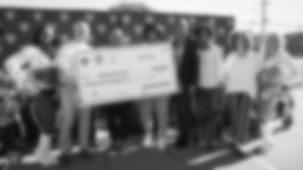 Oakland Raiders president, Marc Badain, and mother of Oakland Raiders running back Marshawn Lynch, Delisa Lynch, present a check of $250,000 to the Oakland Unified School District (OUSD) to help save sports that were eliminated due to budget cuts, at Oakland Technical High School, Friday, August 31, 2018, in Oakland, California.