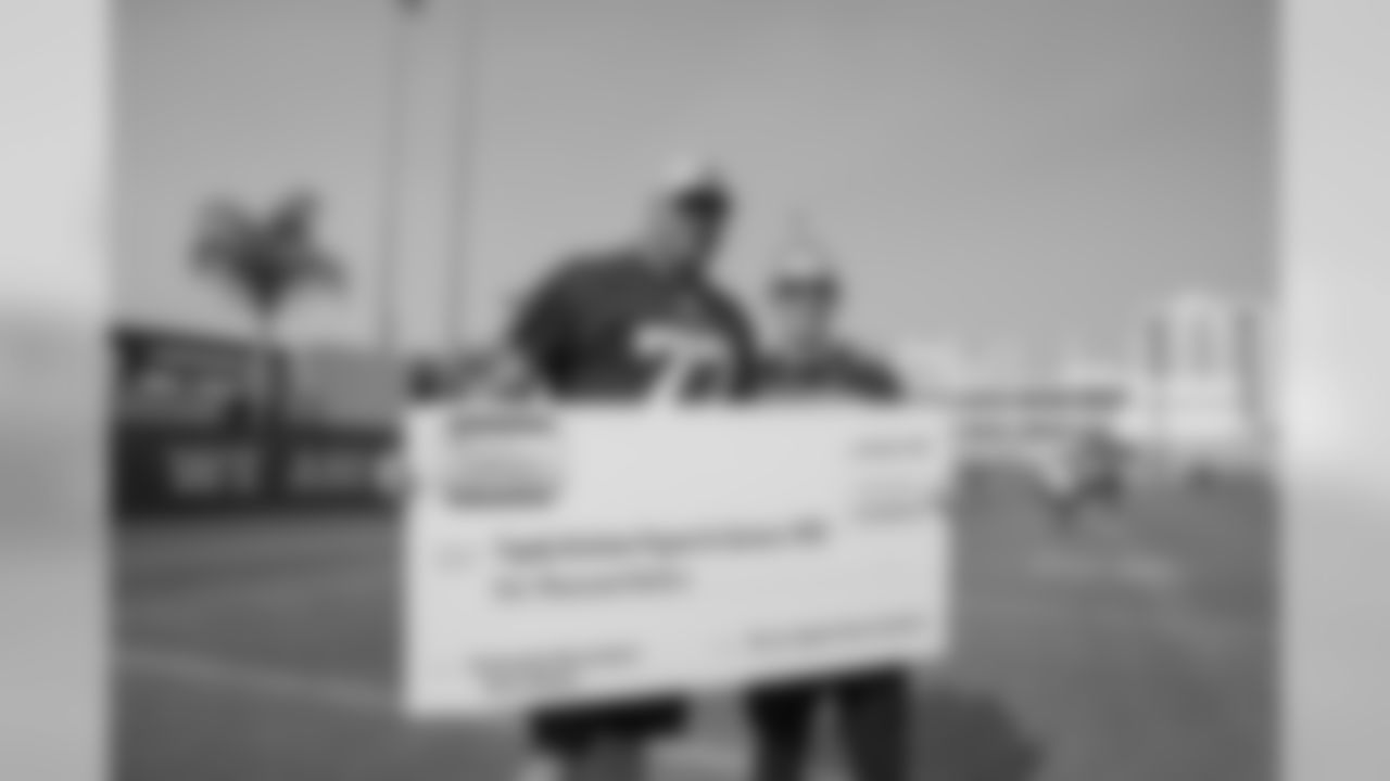 (77) Andrew Whitworth of the Los Angeles Rams poses with a check to the Tragedy Assistance Program for Survivors families with Honda after a walk through , Saturday, November 10, 2018, in Los Angeles, CA. (Jeff Lewis/Rams)