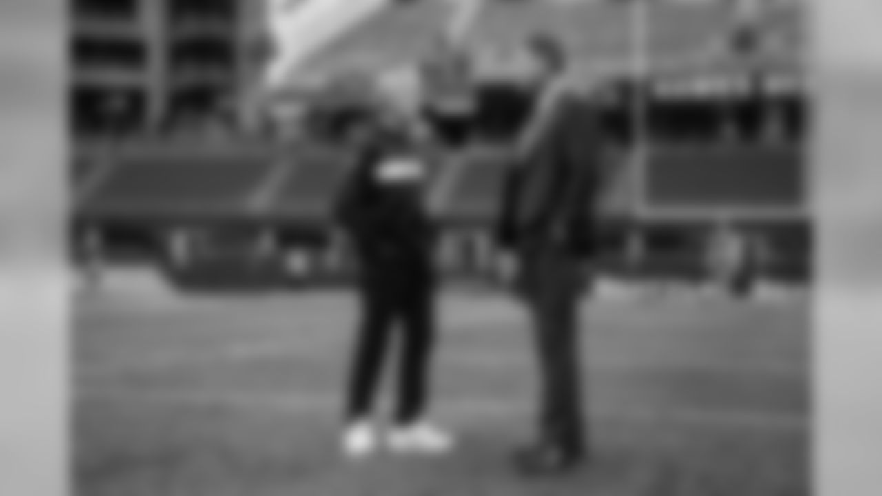Head coach Pete Carroll talks with sportscaster Troy Aikman on the field during pregame.