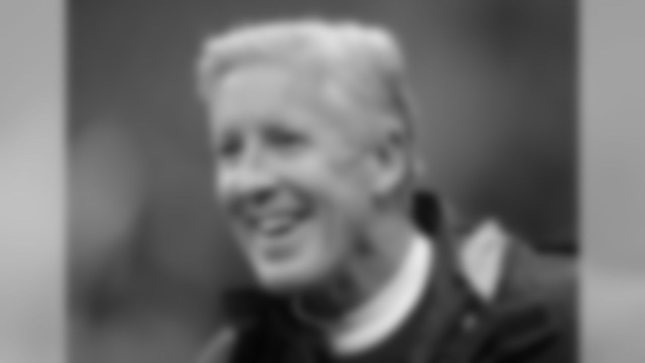 Seattle Seahawks head coach Pete Carroll smiles as he watches his players during the warm-up before an NFL football game against Oakland Raiders at Wembley stadium in London, Sunday, Oct. 14, 2018. (AP Photo/Matt Dunham)