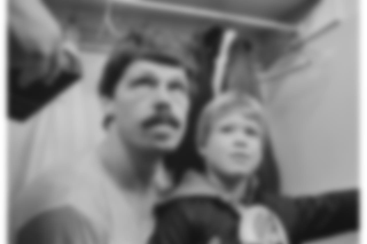 Cincinnati Bengals quarterback Ken Anderson listens to a reporter's question with his six-year-old son, Matt, in the Bengals locker room after AFC playoff win over the Buffalo Bills in Cincinnati on Jan. 3, 1982. Anderson connected with Bengals wide receiver Cris Collinsworth for a touchdown in the late minutes of the fourth quarter to give the Bengals a 28-21 win. (AP Photo)