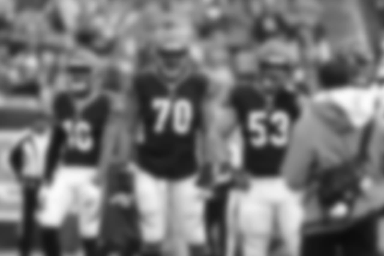 Tackle Cedric Ogbuehi stands with Billy Price awaiting a play from the sideline.