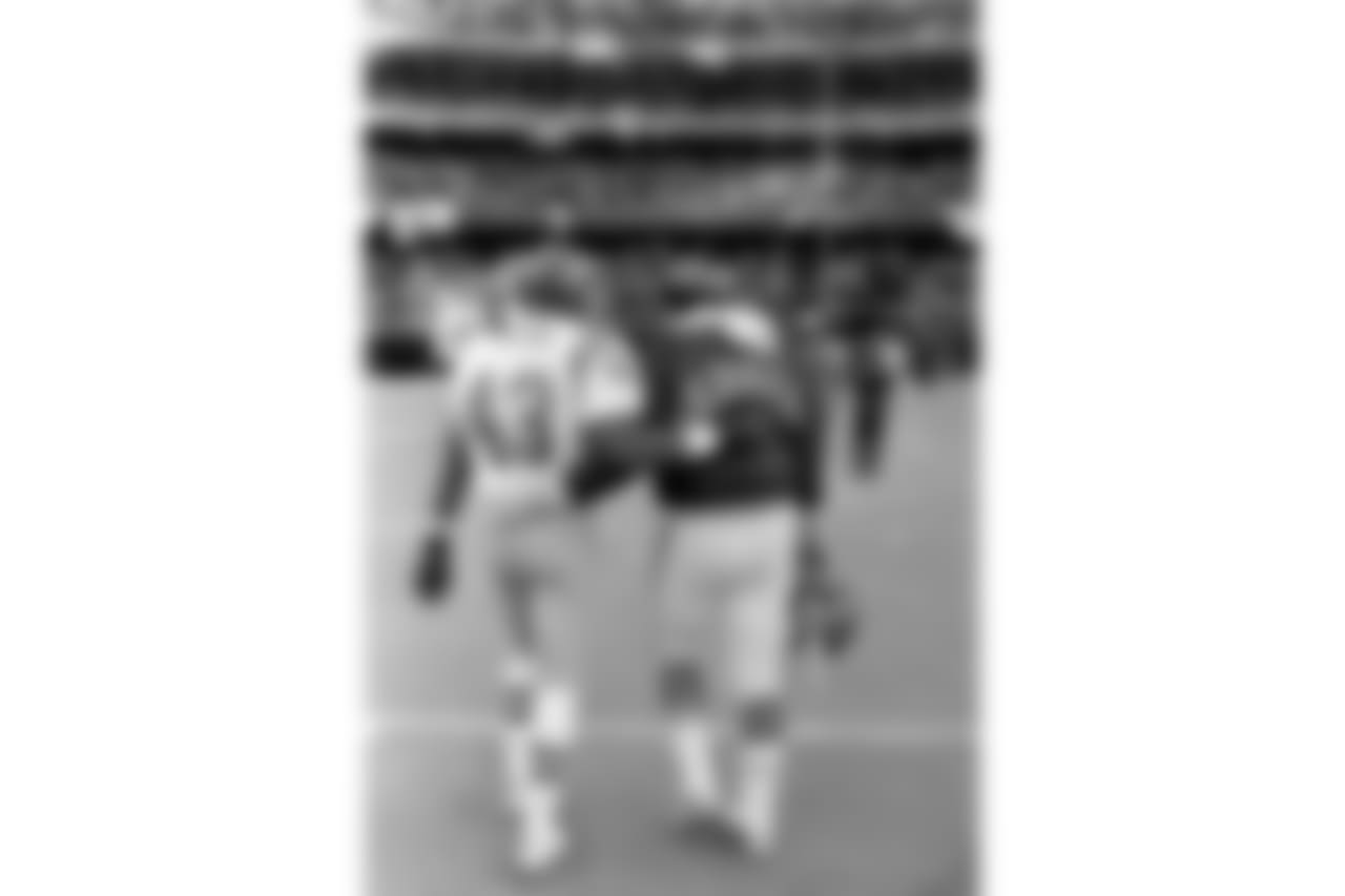San Diego Chargers defensive back Bob Gregor, left, walks off the field with a Cincinnati Bengal in Cincinnati on Jan. 10, 1982. The Bengals defeated the Chargers 27-7 in the AFC championship game. (AP Photo/Harold P. Matosian)