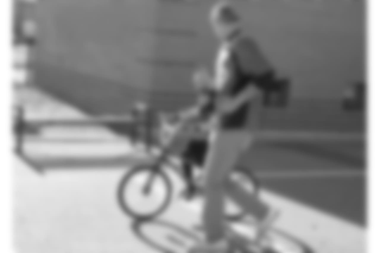 Tim Semisch runs alongside a bike rider during a bike distribution at Green Valley Elementary School in Denver on December 18, 2018.