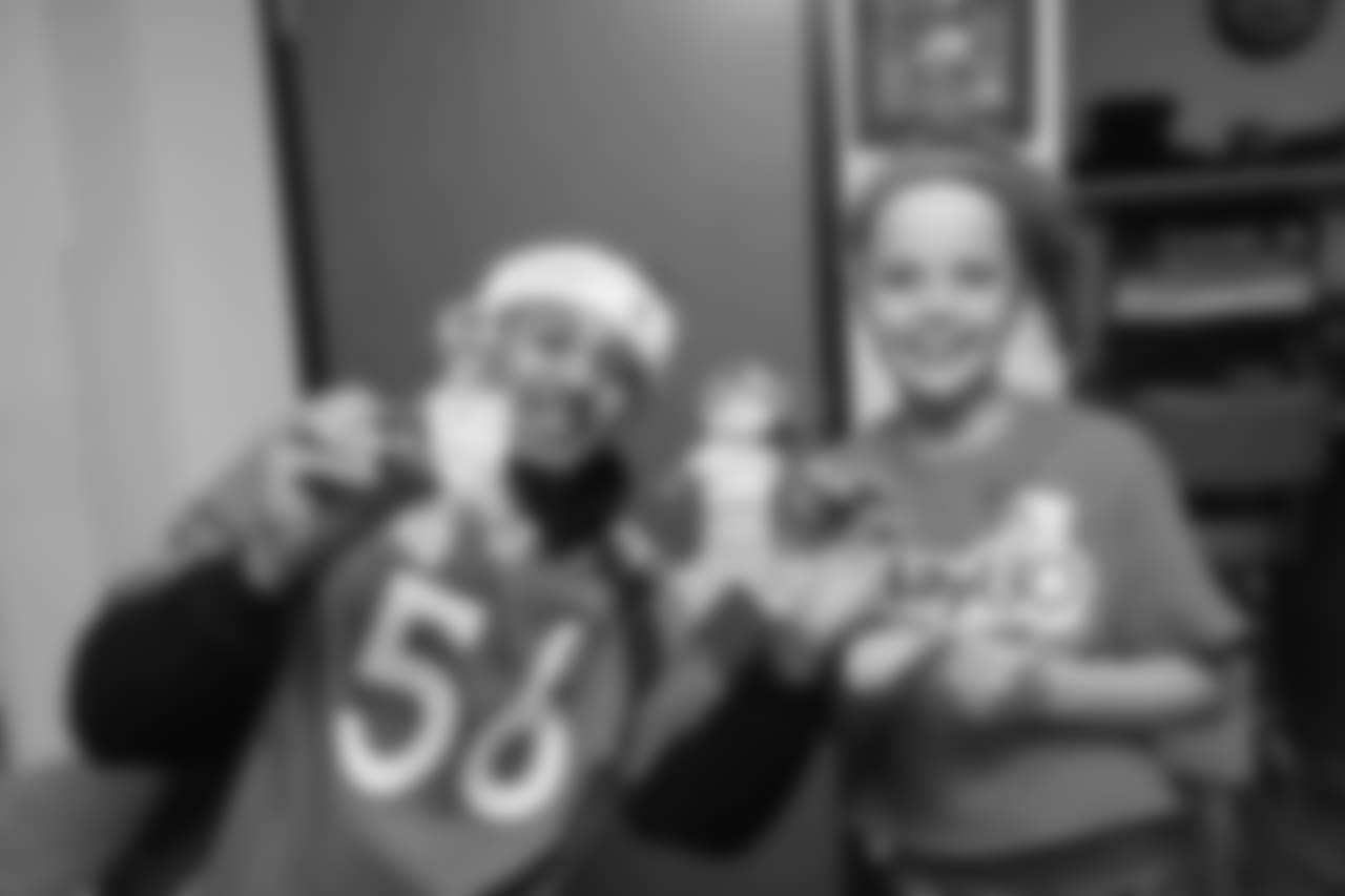Shane Ray and a young girl show off their gingerbread cookies at the Denver Rescue Mission's 19th annual holiday party.