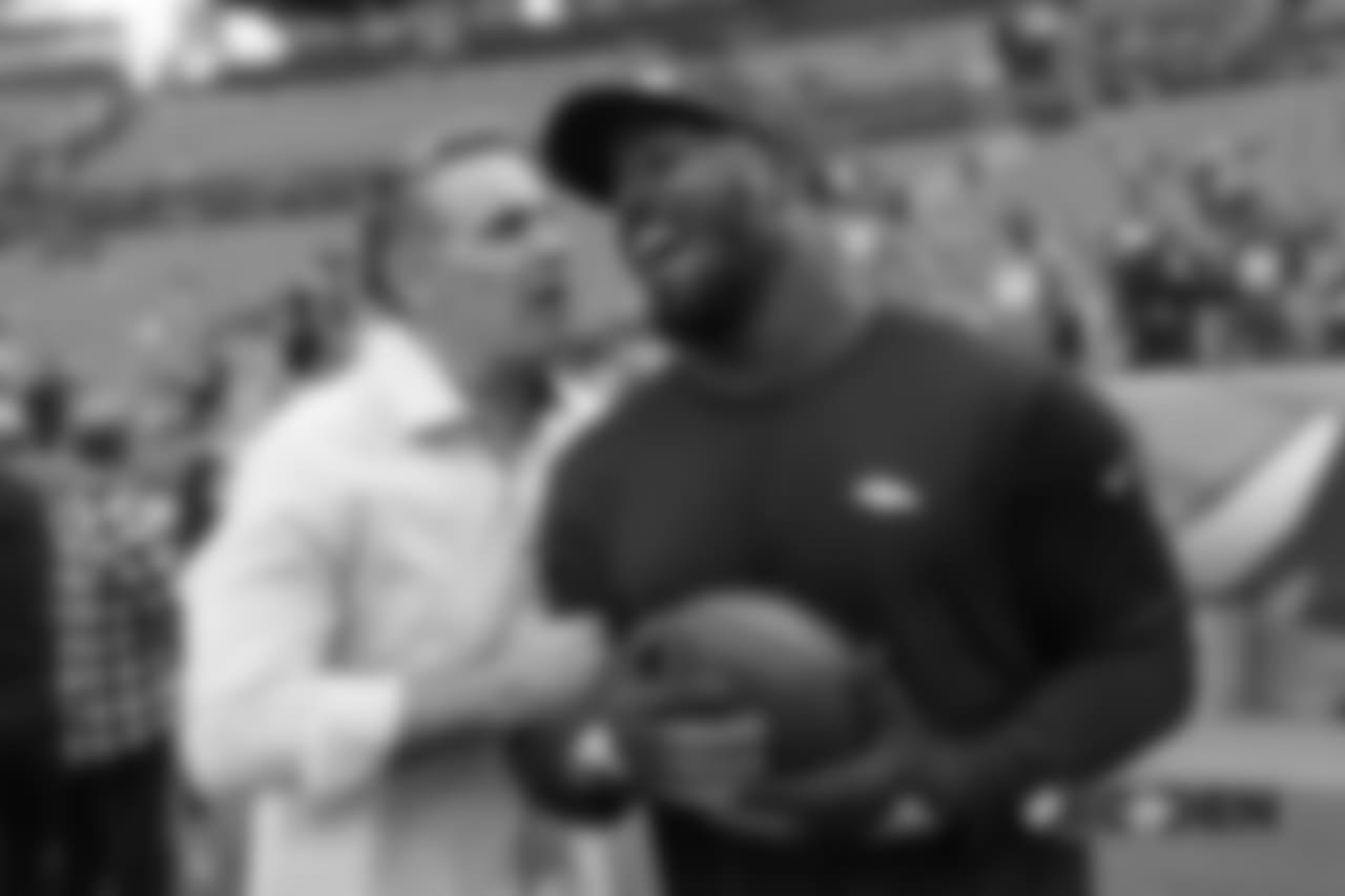 Von Miller and Pro Football Hall of Fame quarterback Kurt Warner share a laugh together while Miller warms up before the Broncos' game against the Chiefs.