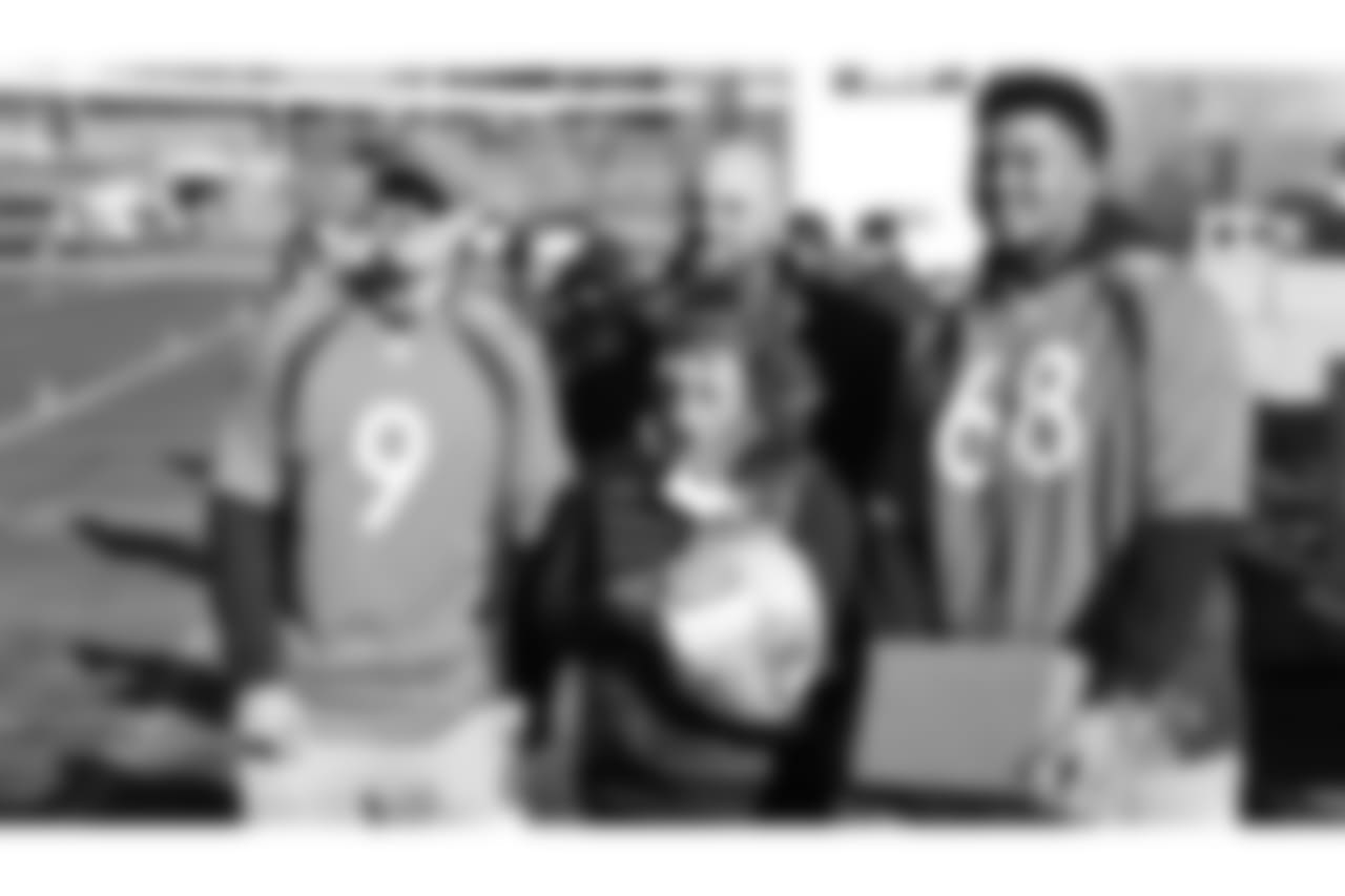(From left) Kevin Hogan, Gino Gradkowski and Elijah Wilkinson pose with a fan during the Denver Rescue Mission's Thanksgiving Turkey in a Box distribution on Nov. 20, 2018
