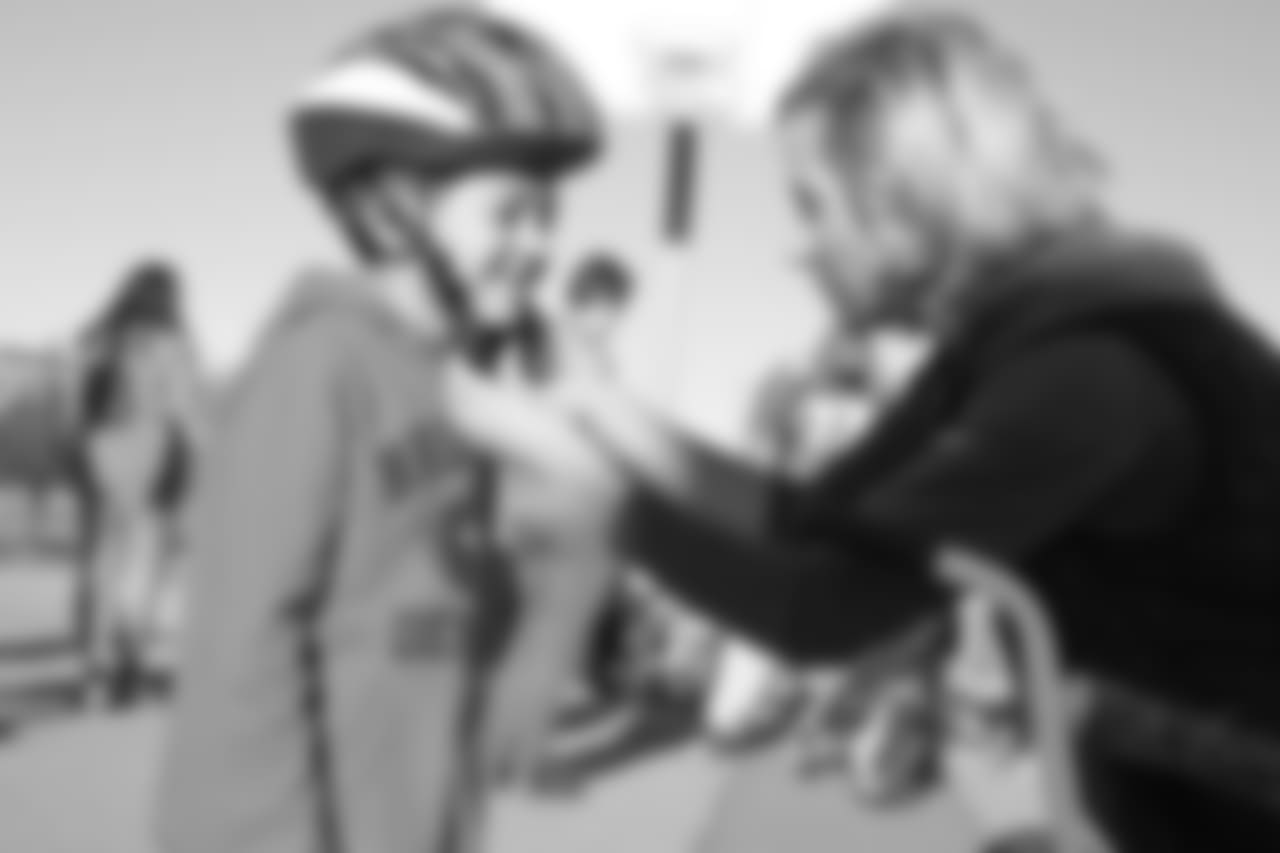 Holly Joseph (right) adjusts a helmet during a bike distribution at Green Valley Elementary School in Denver on December 18, 2018.