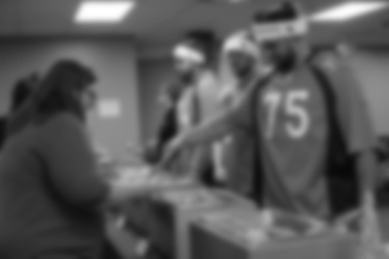 Gino Gradkowski serves dinner at the Denver Rescue Mission's 19th annual holiday party.