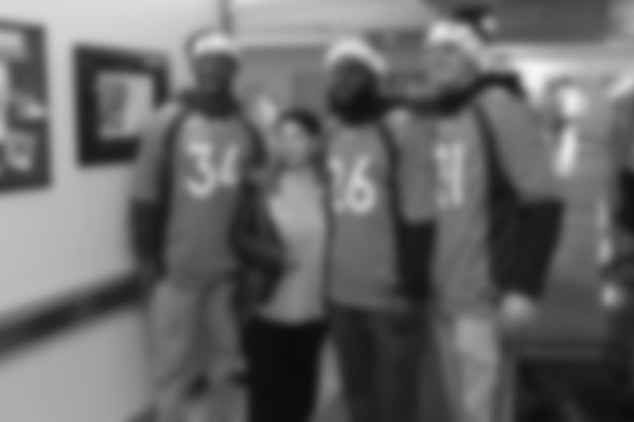(From left) Will Parks, Darian Stewart and Justin Simmons with a hospital employee during a Build-A-Bear distribution at Children's Hospital Colorado in Aurora on December 10, 2018.