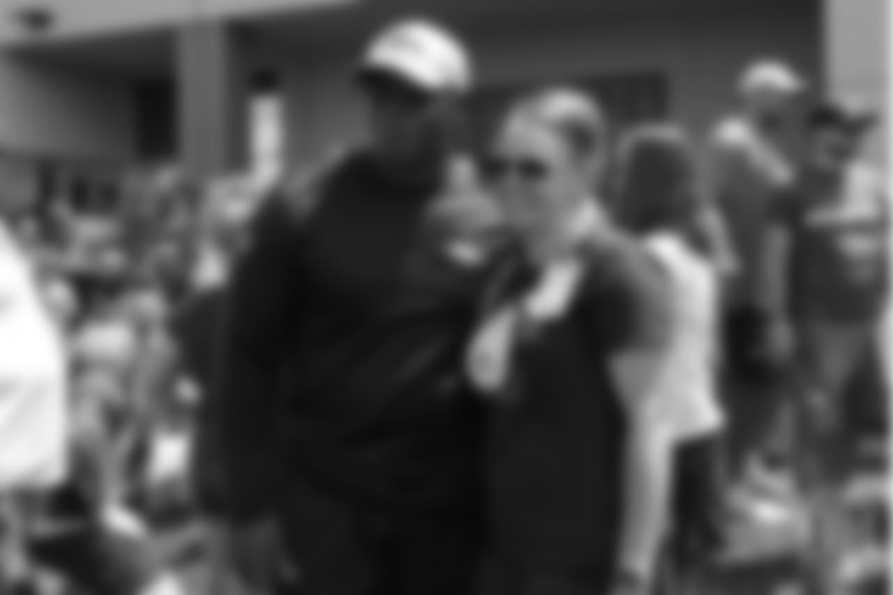 Head Coach Vance Joseph takes a photo with a hospital representative from Children's Hospital Colorado's burn unit after the final day of OTAs on June 7, 2018 at UCHealth Training Center.