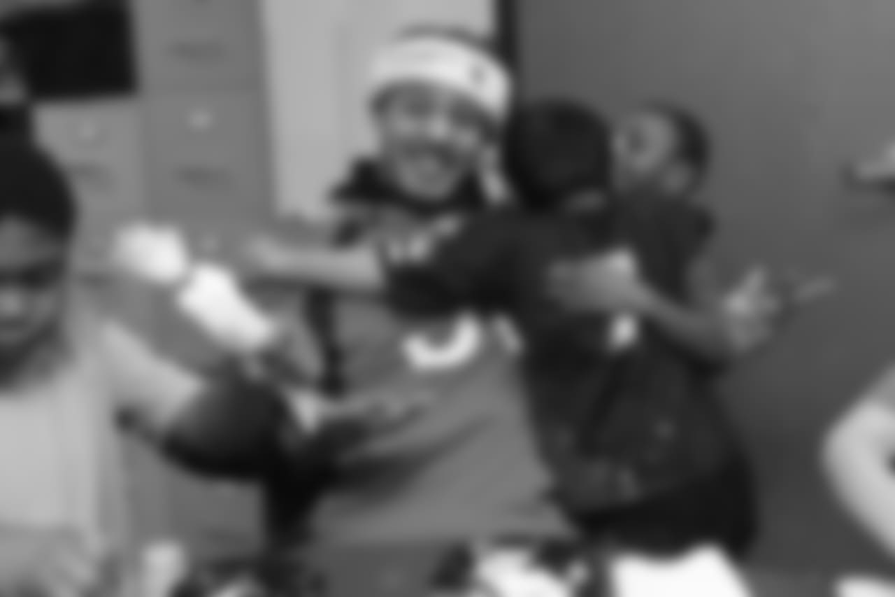Shane Ray receives a hug from two boys at the Denver Rescue Mission's 19th annual holiday party.