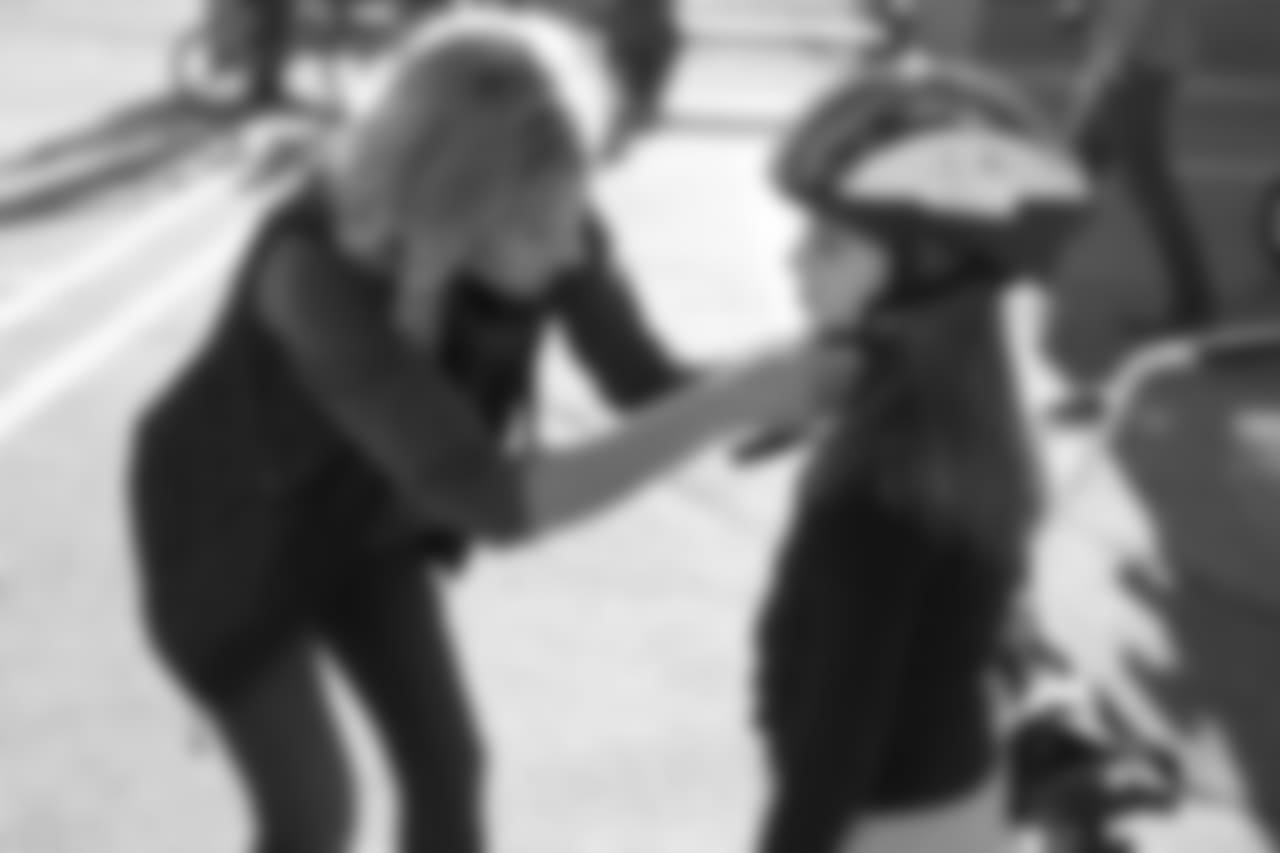Holly Joseph (left) adjusts a helmet during a bike distribution at Green Valley Elementary School in Denver on December 18, 2018.