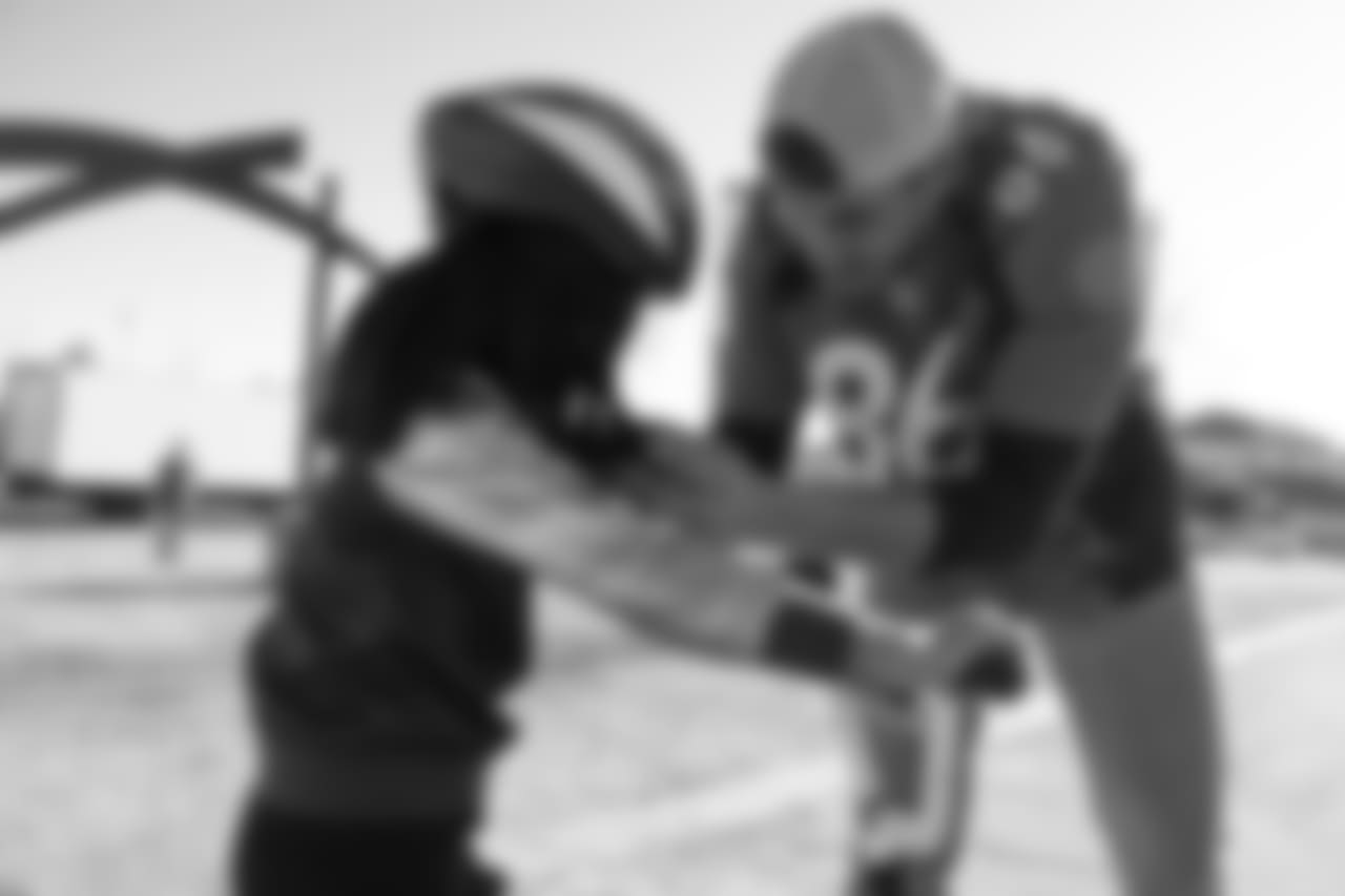 Tim Semisch adjusts a helmet during a bike distribution at Green Valley Elementary School in Denver on December 18, 2018.