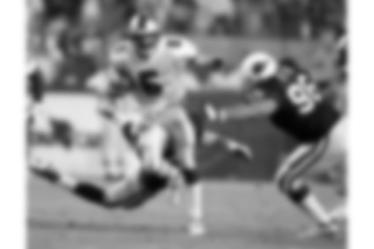 San Francisco 49er quarterback Jeff Garcia scrambles through the Arizona Cardinal defense to gain first down yardage during the fourth quarter of the 49ers 24-10 victory Monday, Sept. 27, 1999, in Tempe, Az. The Cardinals Brad Ottis moves for the tackle.