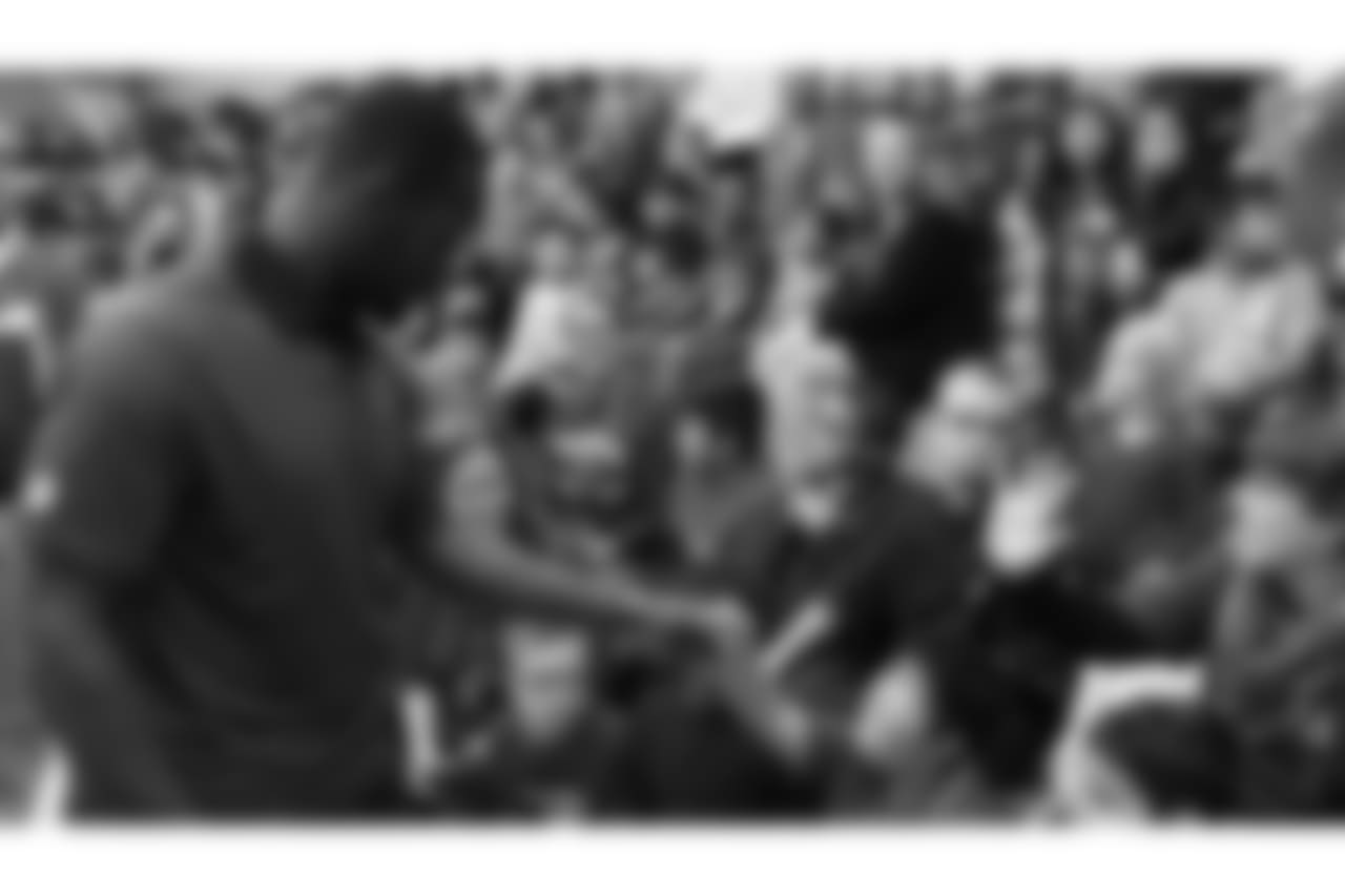 A fist bump between Derrick Coleman and a student.