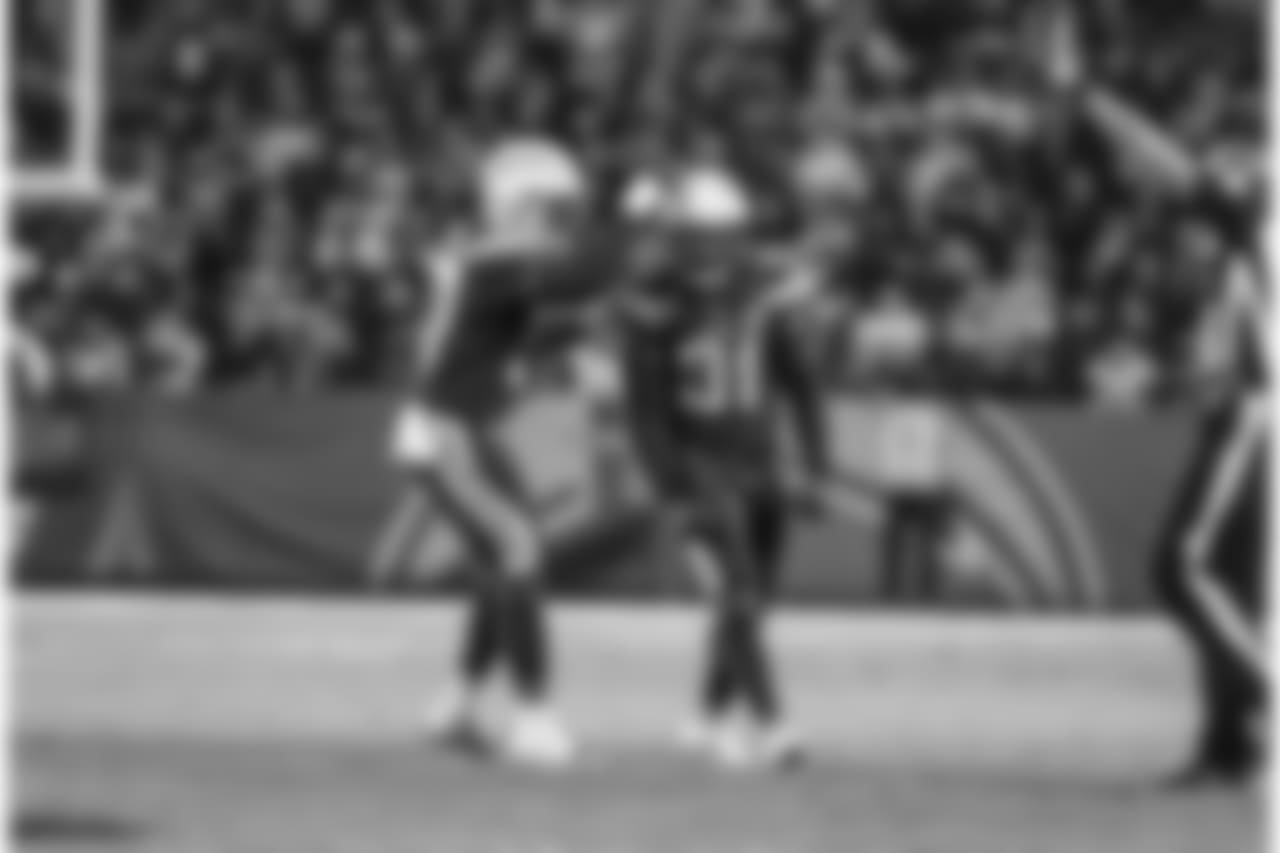 Jatavis Brown and Adrian Phillips celebrate Phillips' tackle during the Week 16 matchup against the Baltimore Ravens at ROKiT Field at StubHub Center.