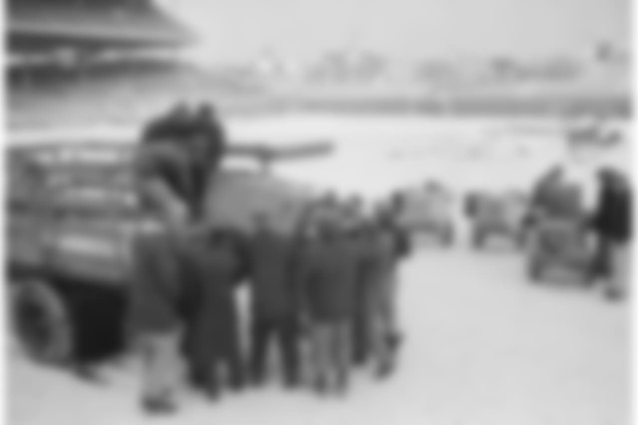Bleak Wrigley Field, covered with new snow, gets a warm-up crew in Chicago, Dec. 23, 1963. They're unloading devices which provide a hot air flow calculated to soften frozen playing field, now under tarpaulins, upper left. The New York Giants and the Chicago Bears will play for the NFL championship. (AP Photo/Charles Knoblock)